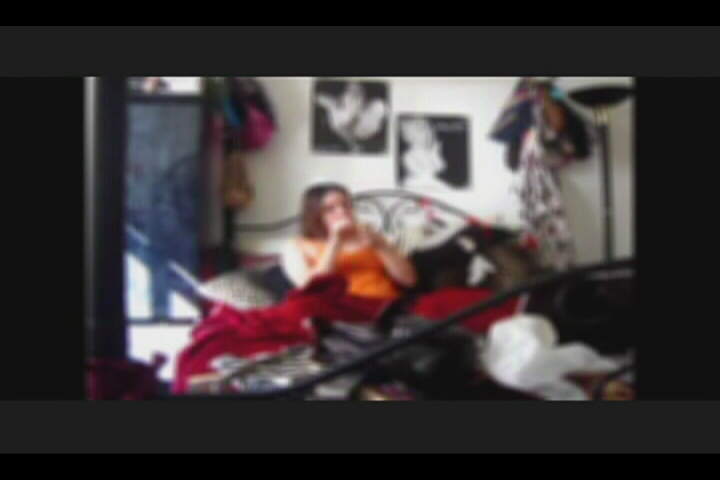 blurry image of woman on bed using camera