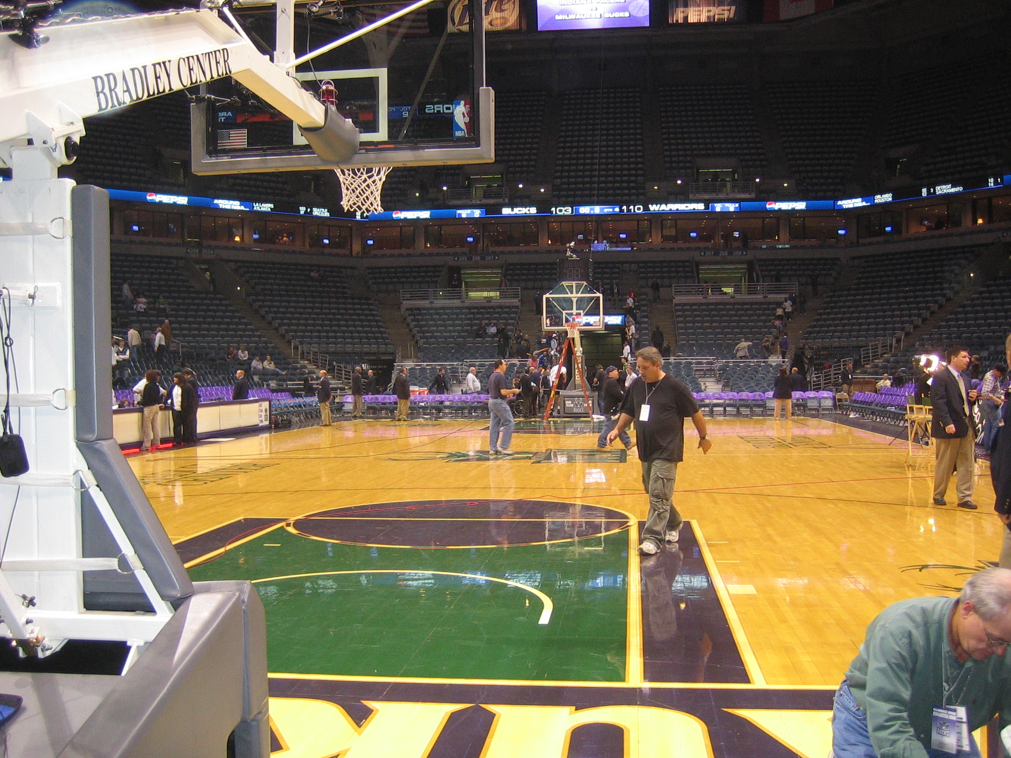 an inside basketball court is seen with players in it