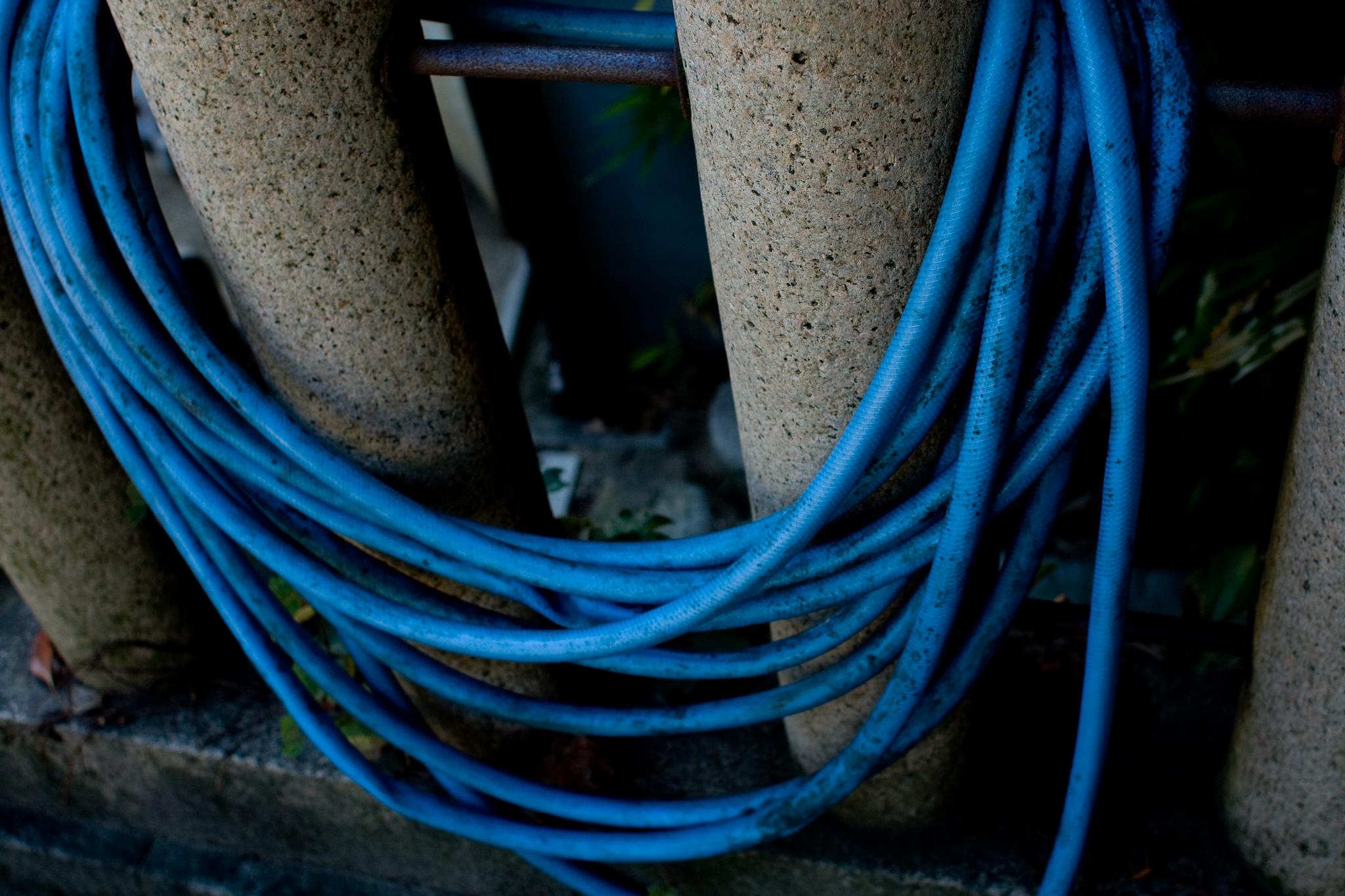 a blue rope tied to a fence around poles
