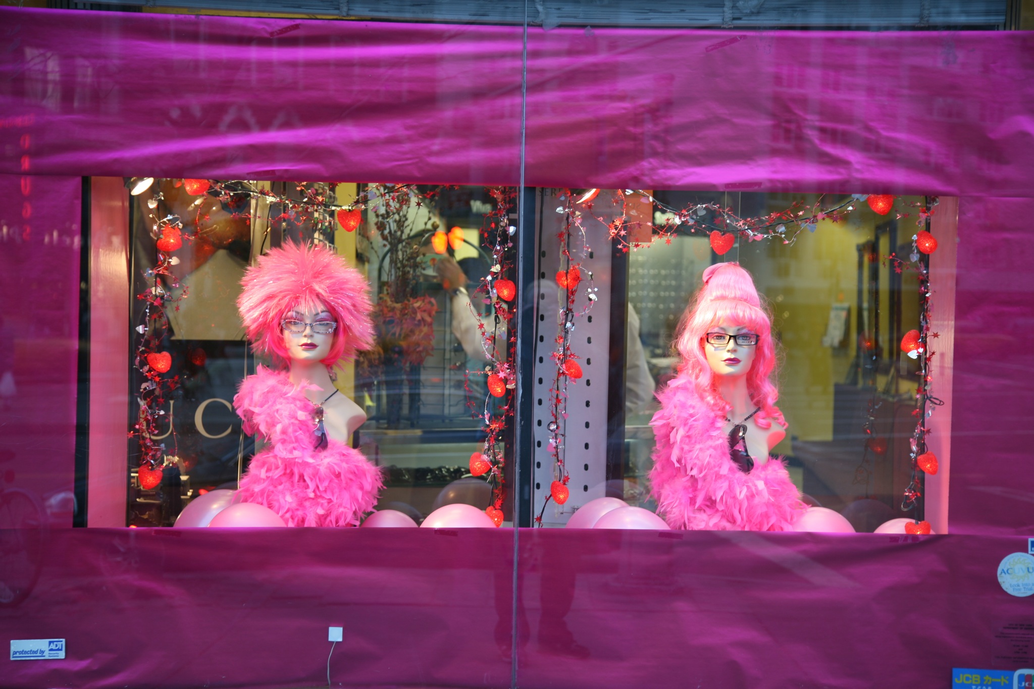 two display windows containing two mannequins in bright pink fur