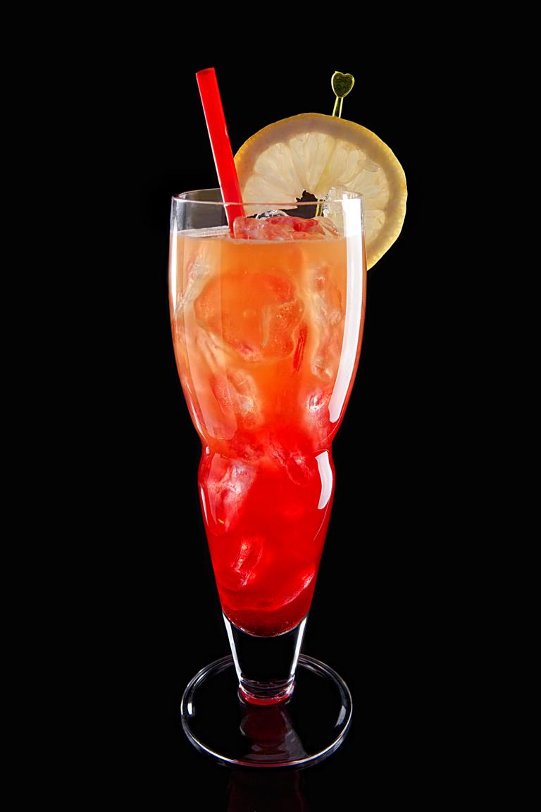 a tall glass with a cocktail inside on a black table