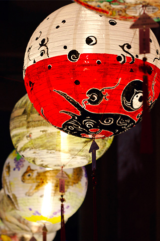some chinese paper lanterns are hanging by the lights