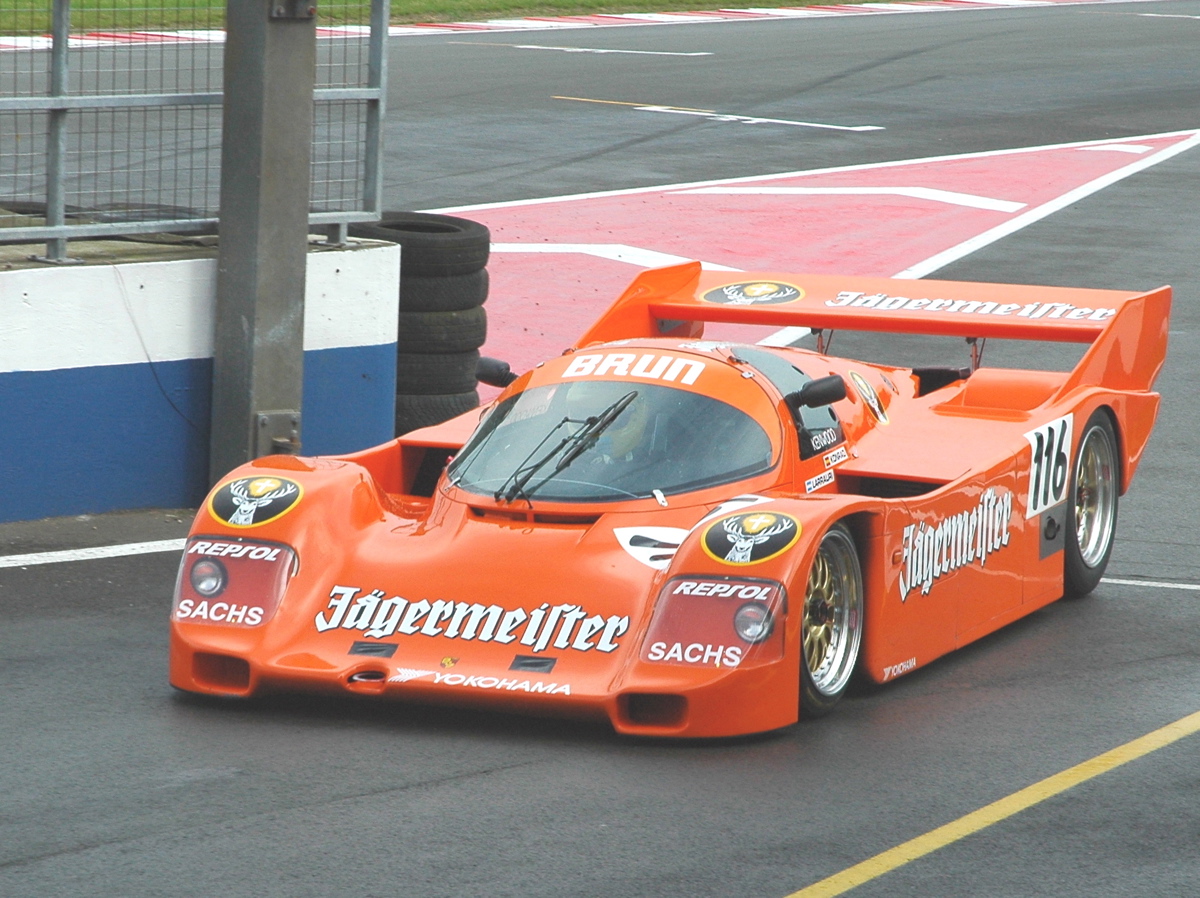an orange sports car driving on a race track
