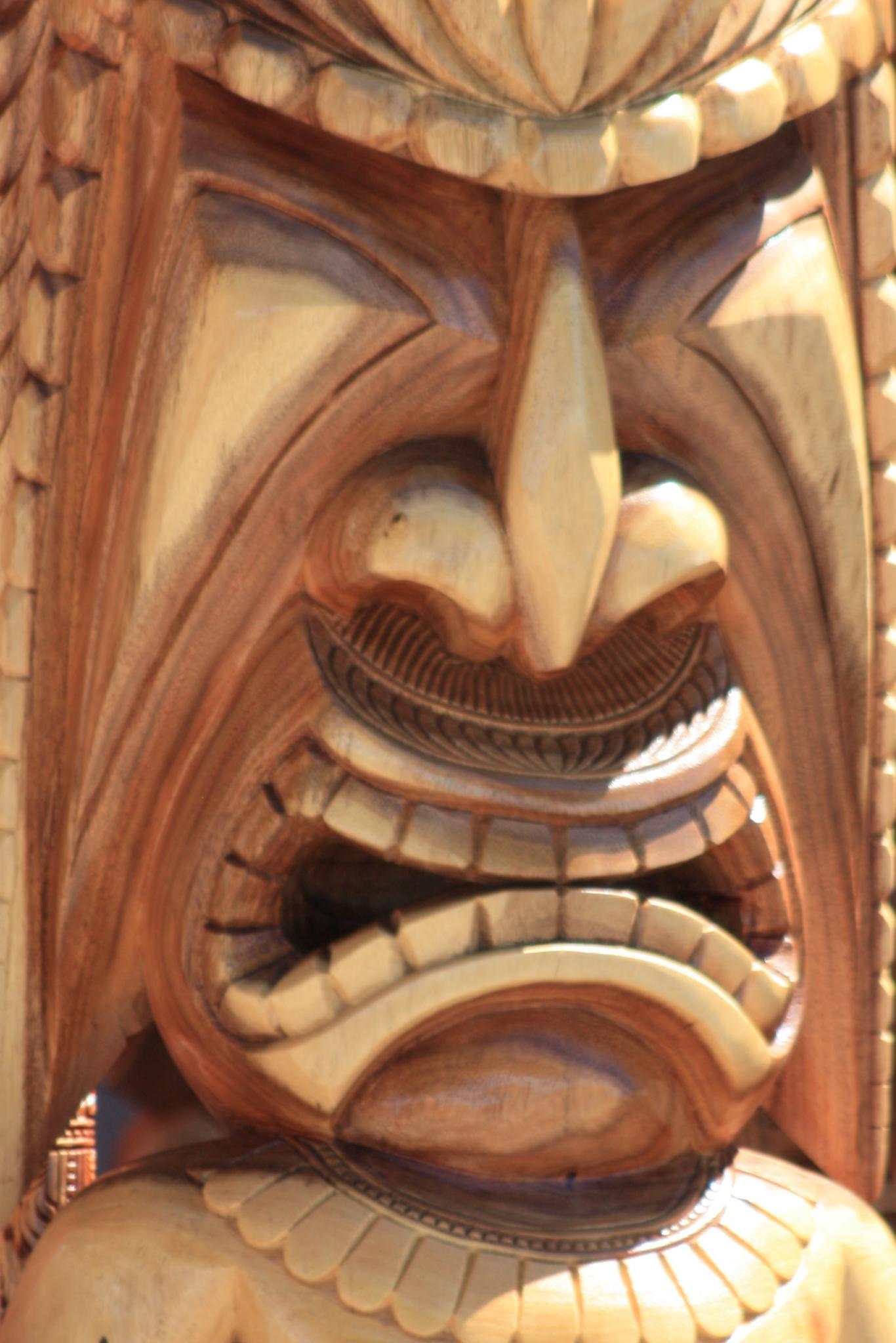 a large face carved on the side of a wood piece