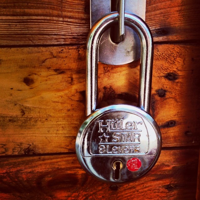 a padlock on a wooden door with words written on it