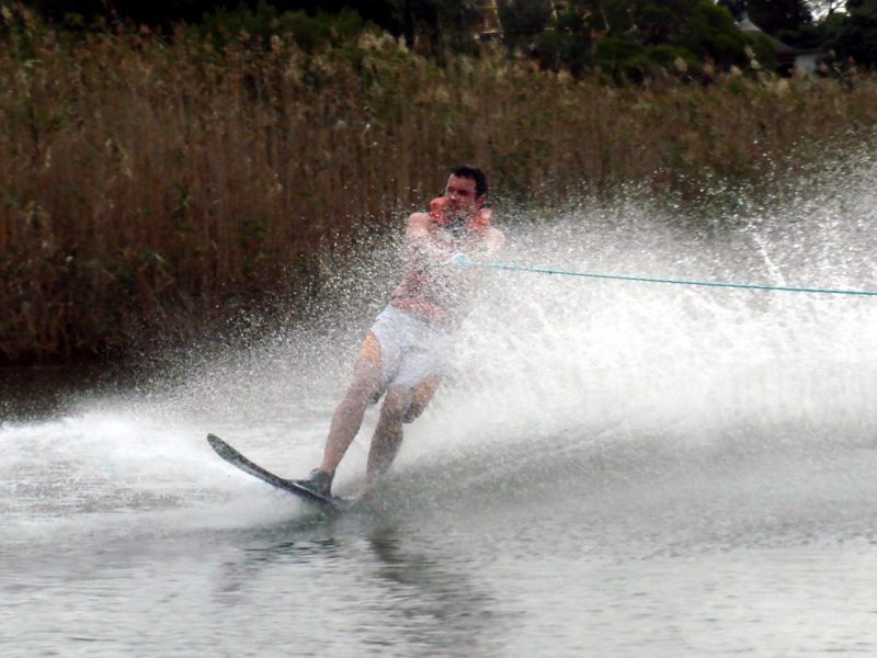 a man riding skis holding onto the rope while being pulled by a boat