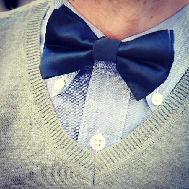 a man in a sweater wearing a bow tie