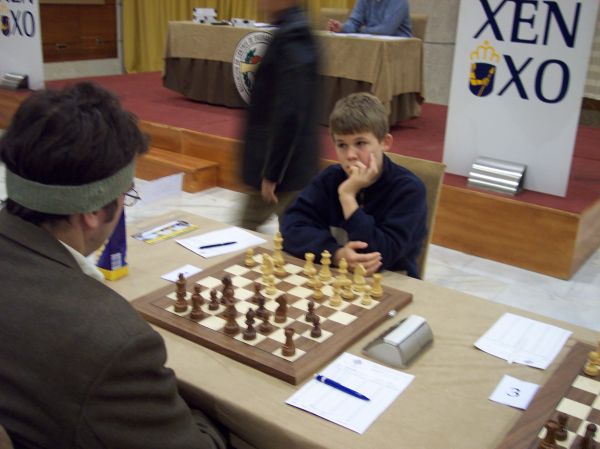 a boy and man playing chess at an event
