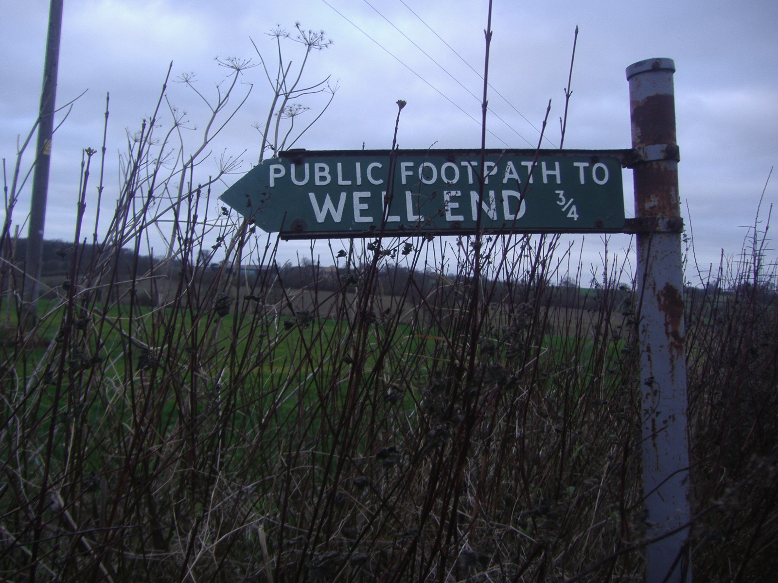 a sign points to the public footpath to well - end