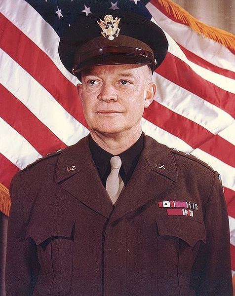 a man in uniform standing in front of a flag