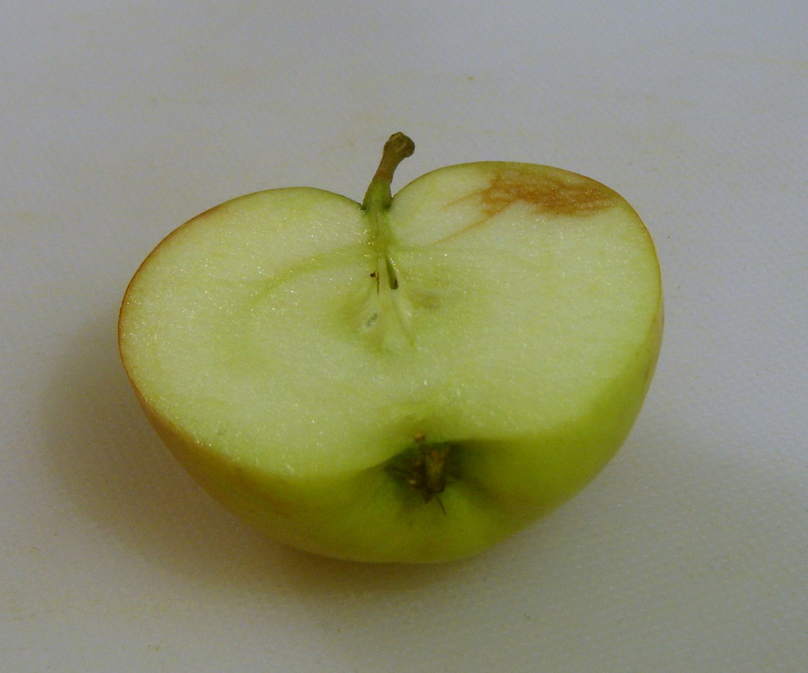 a green apple sliced into pieces sitting on a table