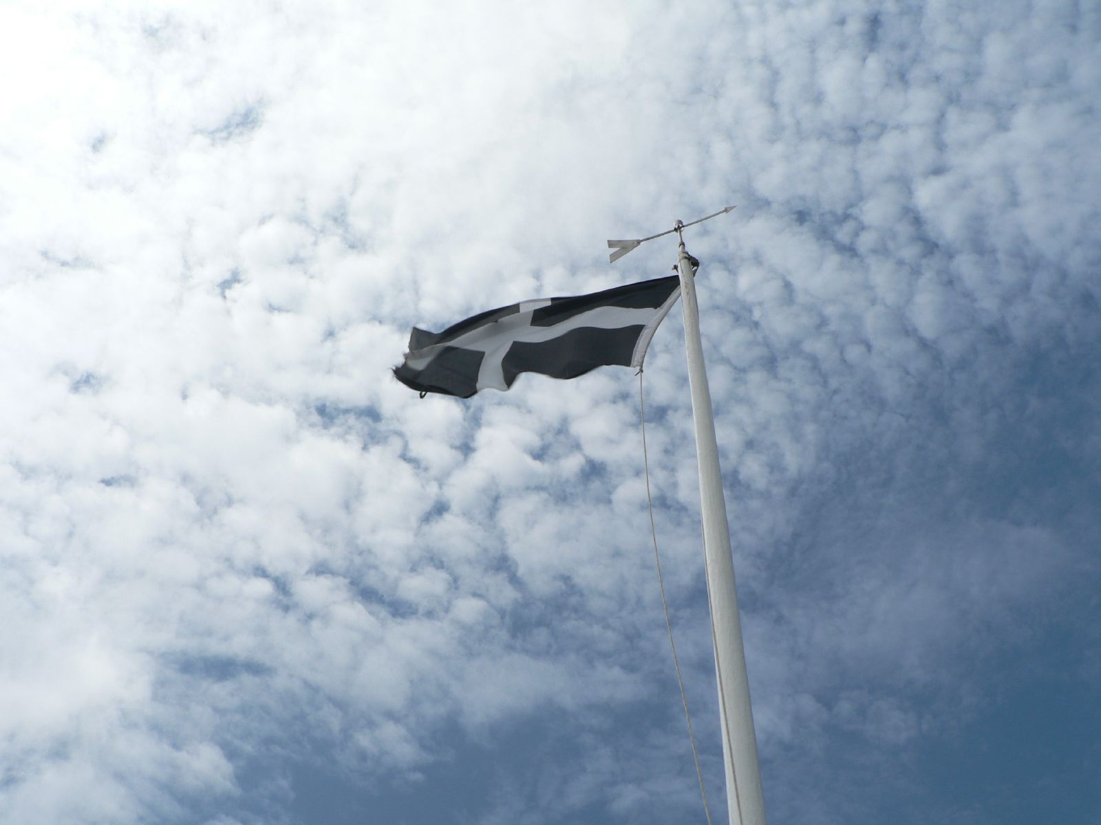 a black and white flag flies through the clouds