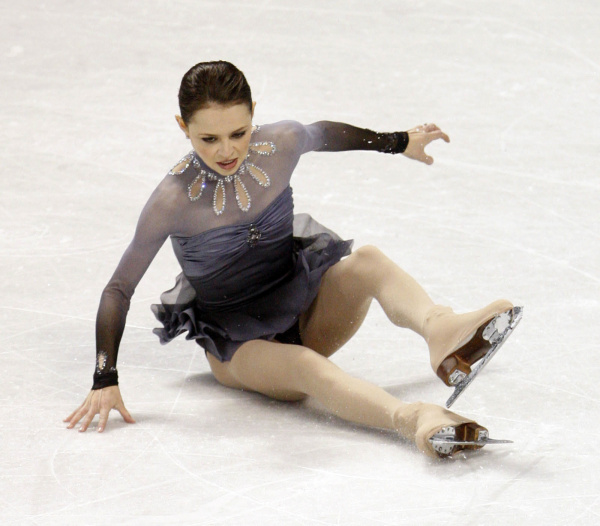 a woman skating on ice with one leg bent