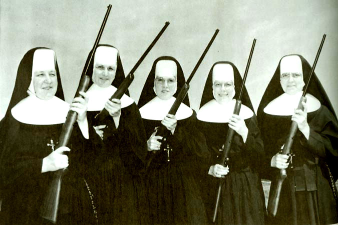 four women holding their long sticks and wearing nun's robes