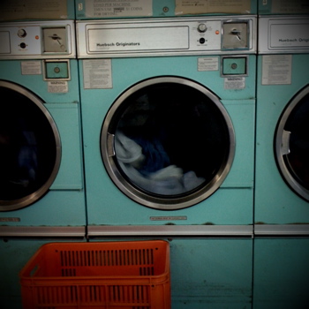 two washers sit inside of a green laundry machine