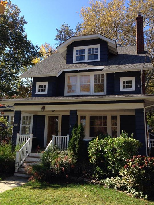 a blue house in the fall has white trim