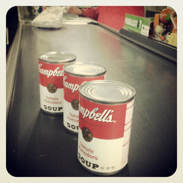 three canisters of soup sitting on a table