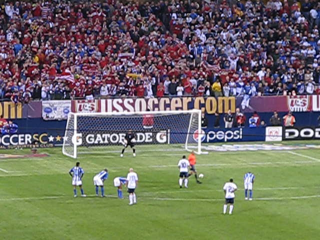 soccer players standing on a field in front of a crowd