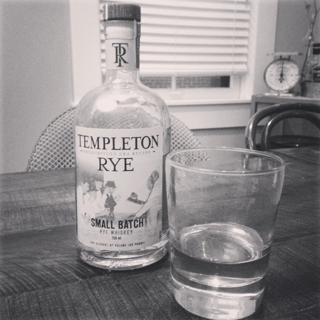 a black and white po with a small s glass next to an empty temple rye bottle