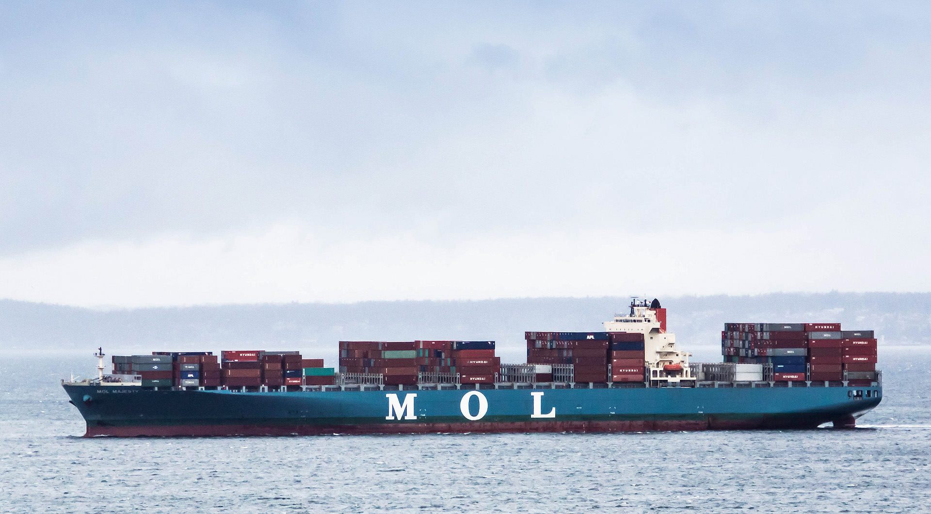 a cargo ship with stacks of cargo on it's deck