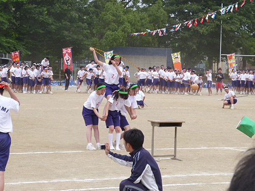 the group of girls are playing on a sandy area