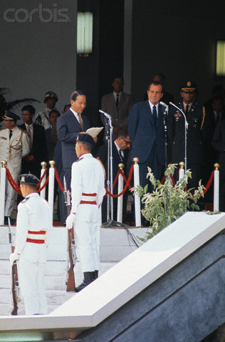 a military man standing next to another person in a white uniform