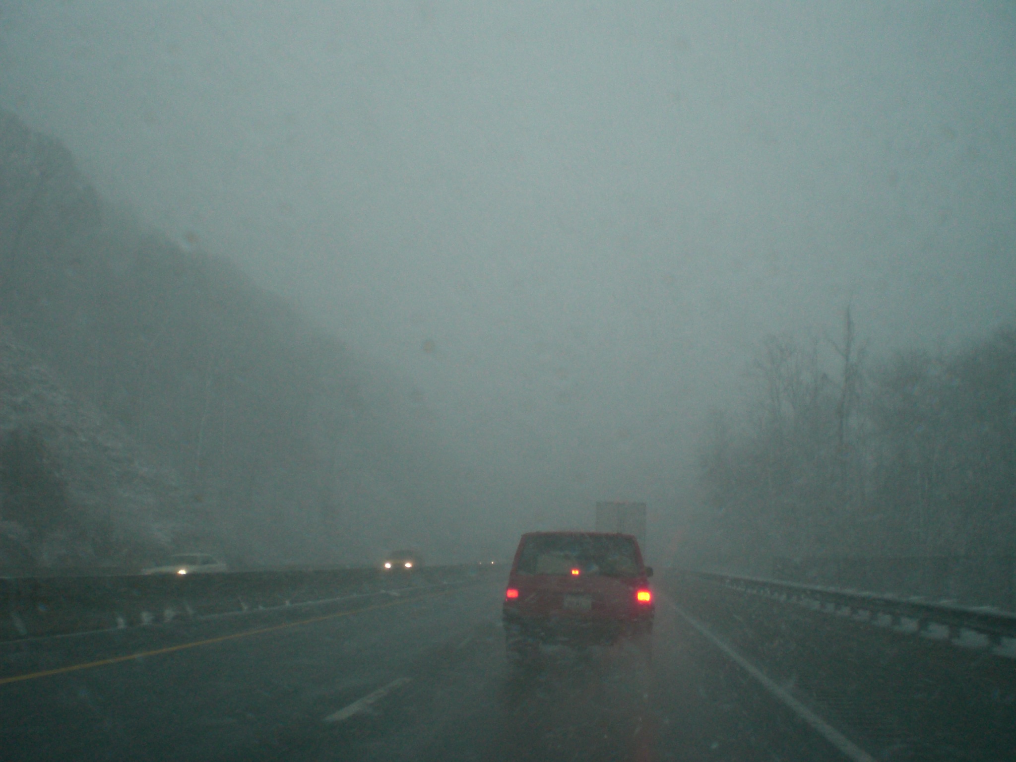 car driving on the side of a foggy road