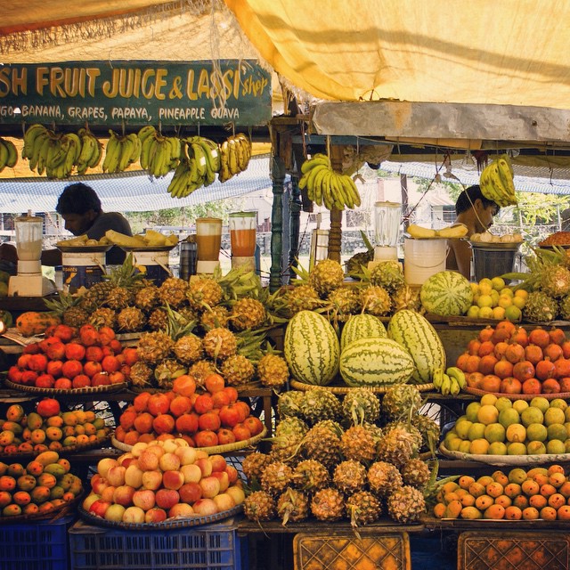 fruits are set out for sale under a tent