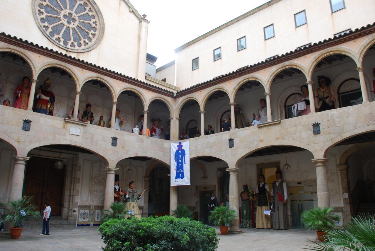 a clock mounted on the wall of a building near a courtyard