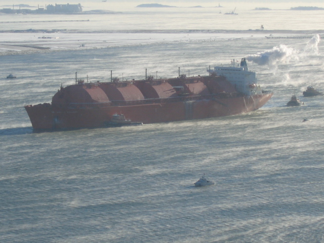 large boat on open water surrounded by ice floes