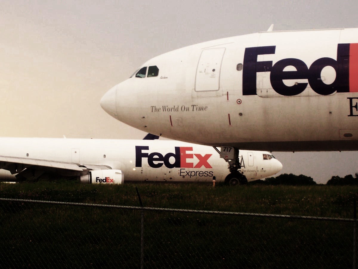 an fedex jet airplane sitting on top of a field