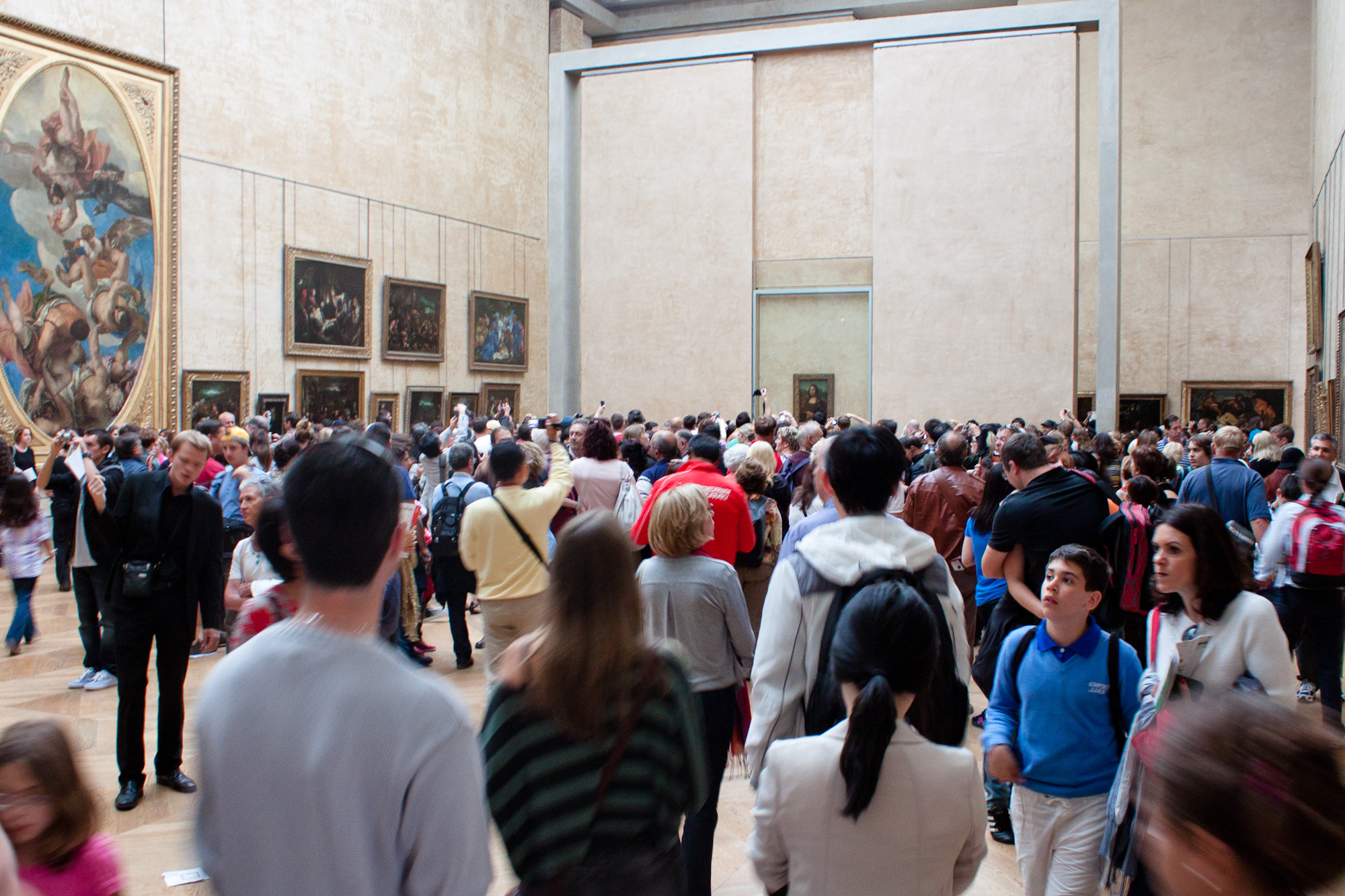 the crowd is gathered in a large room with paintings on the walls