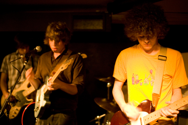 three young men playing instruments in a band
