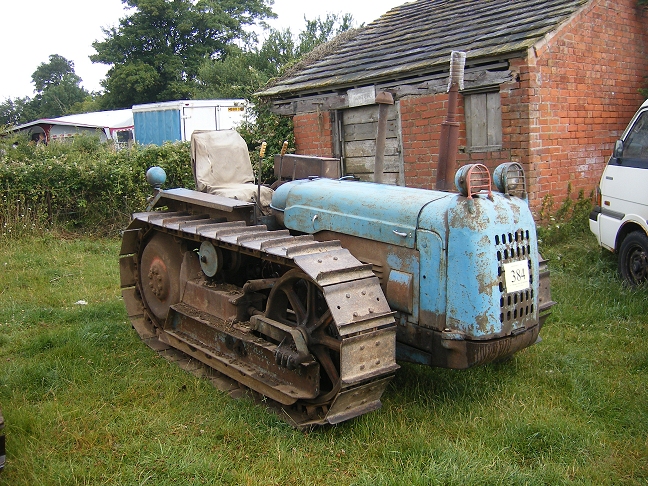 the old style bulldozer is sitting on the lawn