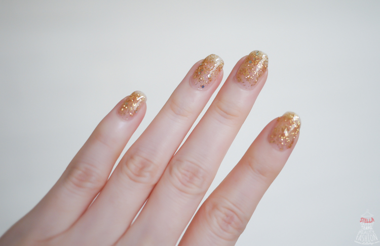 an individual with gold glitter on their fingers and nails