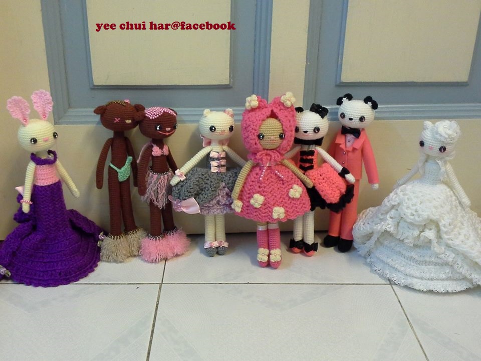several doll - like dolls are lined up against the wall