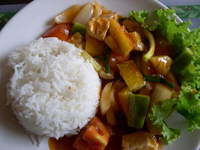 an asian dinner with rice, veggies and sauce