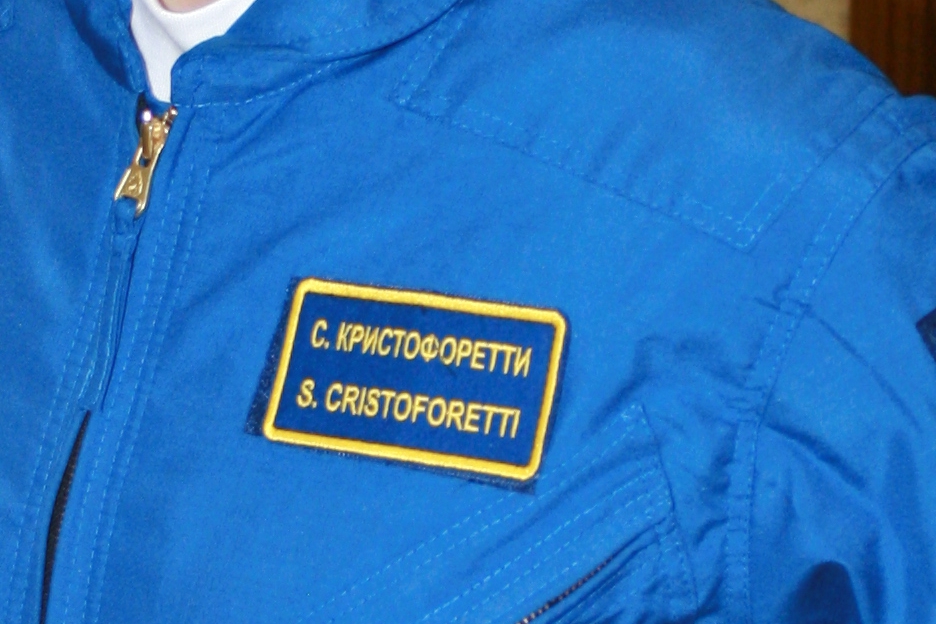 a man wearing a blue jacket with a patch