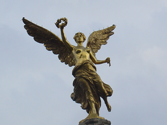 a statue of an angel holding two wings with one hand