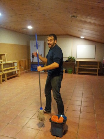 a man holding a broom while cleaning the floor