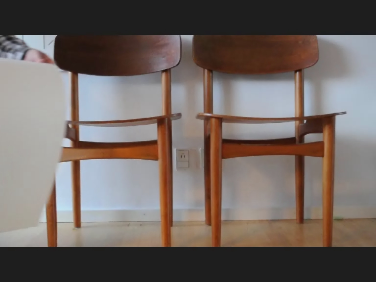 two chairs that are on display against a wall