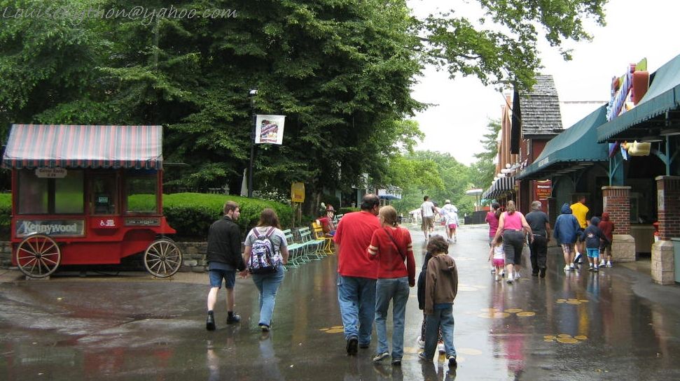 people walking down the street in a rain soaked area