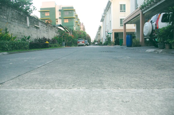 an empty street and parked cars are seen