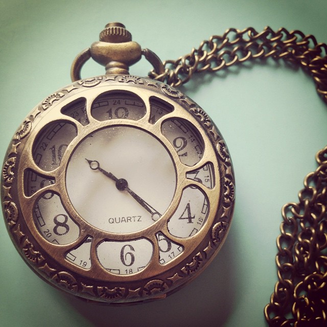 an antique clock that has been hung on a chain