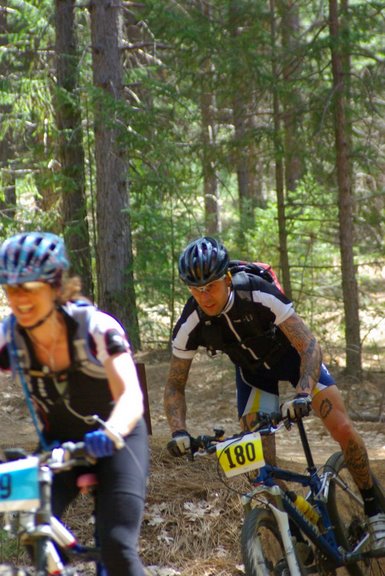 two people on bicycles are riding in the woods