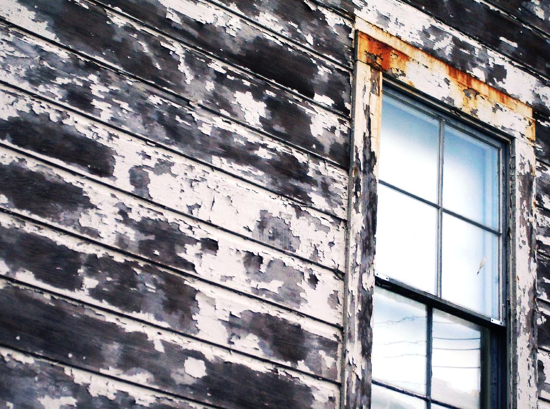 an old wooden building with a broken window