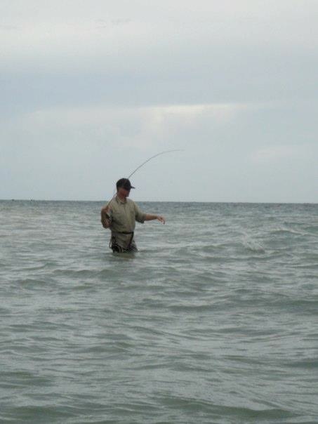 a person standing in the water with a fishing pole