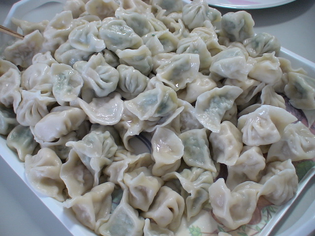 some dumplings on a plate with spoons and plates