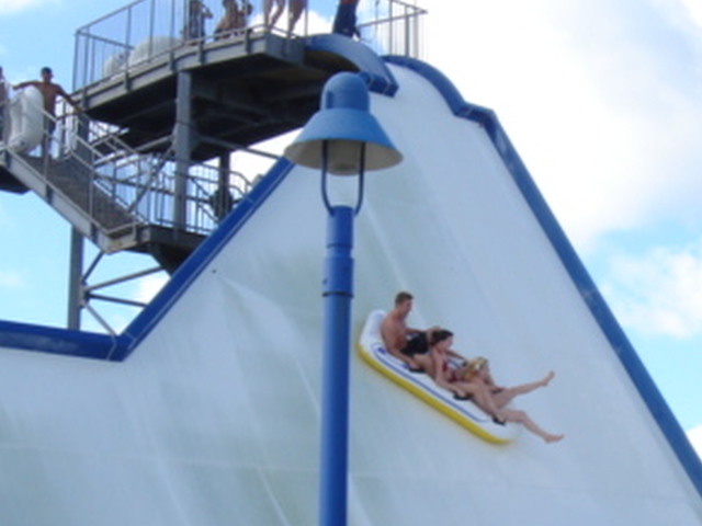 people ride the water slide on a carnival