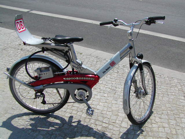 a red and grey bicycle parked on the street